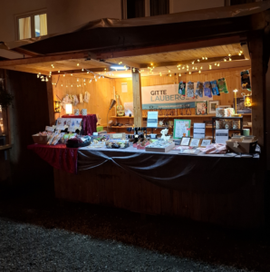 Ein Weihnachtsmarktstand bei Nacht, schön beleuchtet, voller Waren mit Tiermotiven. Im Hintergrund mein Banner "Gitte Härter" mit Logo und Webadresse.