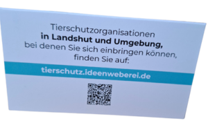 Rückseite einer Klappkarte auf der steht: Tierschutzorganisationen in Landshut und Umgebung, bei denen Sie sich einbringen können, finden Sie auf: tierschutz.ideenweberei.de mit einem QR-Code